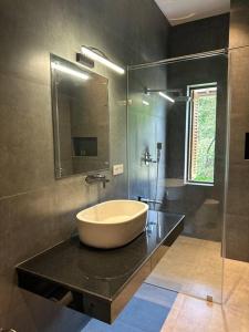 库鲁内格勒Lake Round Luxury House的黑色柜台上带大碗水槽的浴室