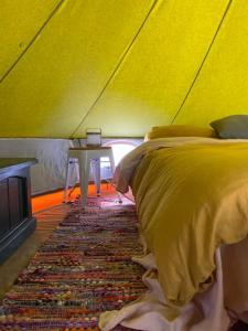 托克姆沃尔Tocumwal Chocolate School Glamping的一间卧室配有一张床,帐篷内配有一张桌子