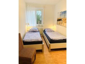 朗格奥Holiday apartment sea air的配有椅子和窗户的客房内的两张床