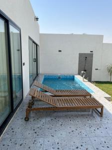 胡富夫شاليهات بالما的一座游泳池,位于一座房子的庭院内