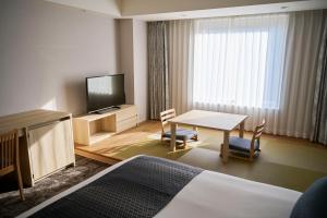 成田成田东武机场酒店的酒店客房设有一张桌子和一台电视机