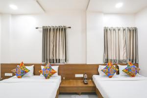 舍地Hotel D Grand的客房设有两张床,配有色彩缤纷的枕头。