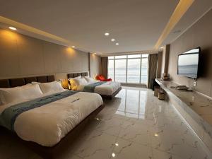 马比尼Luckytito Anilao Resort的酒店客房设有两张床和一台平面电视。