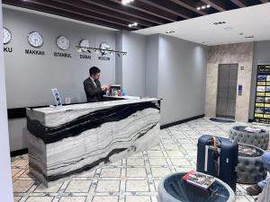 巴库Baku ZamZam Hotel的站在大厅柜台上的人