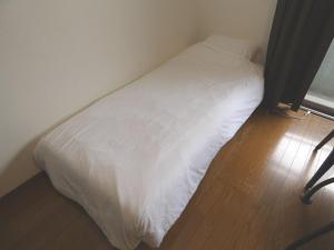 筑紫野市AO Dazaifu / Vacation STAY 61720的铺有木地板的客房内的一张白色床