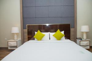 沙湾拿吉沙湾度假酒店的卧室配有一张带黄色枕头的大型白色床。