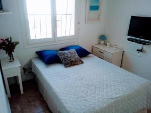 克萨达城casatrace的一间卧室配有一张带蓝色枕头的床和电视。