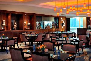 科威特科威特城万怡酒店的用餐室配有桌椅