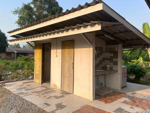 Ban Nam Lai Ta TumNADOHN Camper的一座小房子,在庭院设有屋顶