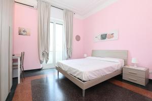 热那亚SAN MARTINO HOUSE的卧室设有粉红色的墙壁和一张带书桌的床