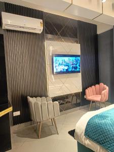 斯利那加Lieu D Amour的一间卧室配有两把椅子和一台墙上的电视