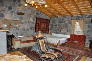 SelimDoğunun Taş Evleri的一间卧室配有一张床、一张沙发和一把椅子