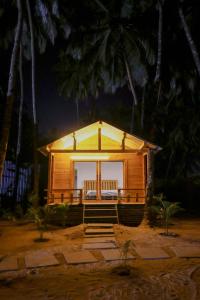 卡纳科纳The Pearl Beach Resort的小屋在晚上设有门廊
