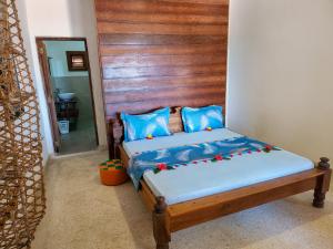 吉汶瓦Villa NOAH BEACH ZANZIBAR的一间卧室配有一张带木制床头板的床