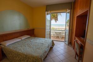 阿布鲁齐的罗塞托Hotel Roma Sul Mare的一间卧室配有一张床,享有海景
