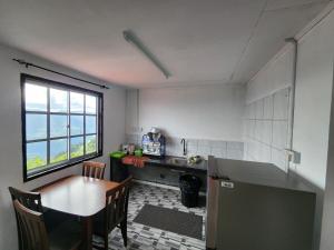 昆达桑Hillside Villa的厨房配有桌子、桌子和窗户