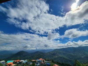 昆达桑Hillside Villa的享有多云的天空的山景