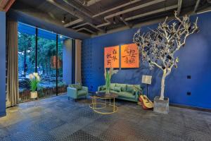 桐乡乌镇秋喜艺术酒店的客厅配有沙发、桌子和一棵树