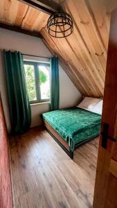 比斯库佩茨Dadajowa Osada - Dadaj的一间卧室设有一张绿色的床和一个窗户。