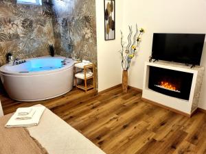 奥佩拉B&B Italo House的一间带浴缸、电视和壁炉的客厅