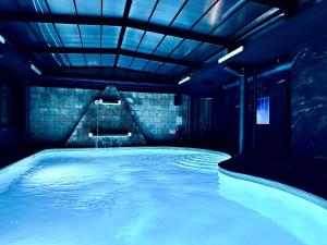 特尔尼Hotel Michelangelo Palace & SPA的室内的游泳池,有蓝色的灯光