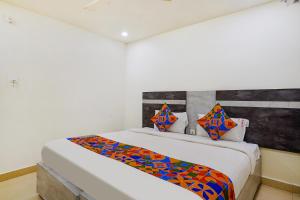 维杰亚瓦达FabHotel Ambika Elite的一间卧室配有一张带彩色毯子的床