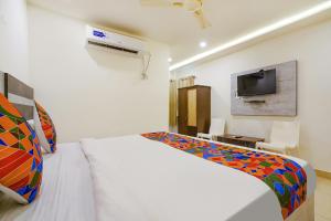 维杰亚瓦达FabHotel Ambika Elite的卧室配有白色的床和电视