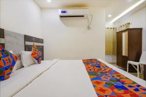 维杰亚瓦达FabHotel Ambika Elite的一间卧室配有一张带彩色毯子的床