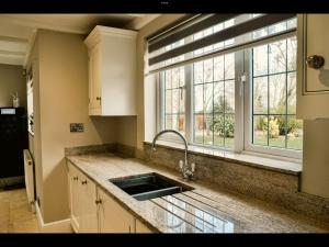劳斯Brackenborough Lakes Resort的厨房设有水槽和窗户。