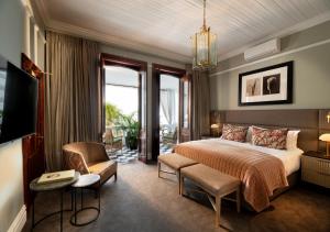 开普敦The Winchester Hotel by NEWMARK的配有一张床和一把椅子的酒店客房