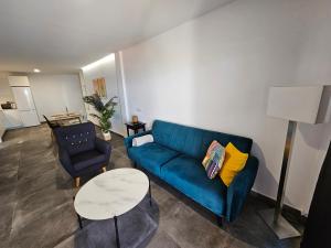 塔扎克蒂Las Norias Apartamentos & Grill的客厅配有蓝色的沙发和桌子