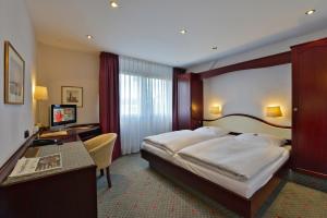 科隆帝国酒店的酒店客房设有一张大床和一张书桌。