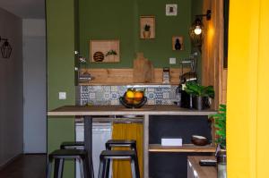 加桑C-FORTY - piscine - plage的厨房设有绿色的墙壁和带凳子的台面
