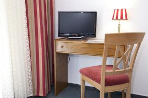 维林根Bio-Hotel Upländer Hof的客房设有书桌、电视和椅子