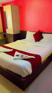 孟买Hotel Icon International Airport Mumbai的红色墙壁的客房内的两张床