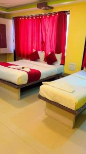孟买Hotel Icon International Airport Mumbai的配有红色窗帘的客房内的两张床