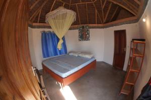姆特瓦拉AFLII Beach Club ( Zanzibar Beach )的一间卧室设有一张床和木制天花板