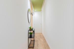 维罗纳Natural Chic - 10 min dall'Arena & Garage的走廊上设有白色墙壁、白色地板和盆栽植物