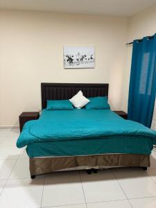 迪拜Fully Furnished Studio Appartment next to Sharaf DG metro Station的一间卧室配有一张带蓝色枕头的床