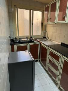 迪拜Fully Furnished Studio Appartment next to Sharaf DG metro Station的厨房配有水槽和冰箱