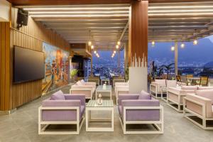 加德满都Regenta Place Sabrina Kathmandu Nepal的餐厅设有紫色椅子和平面电视。