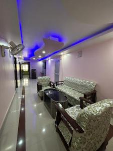 阿加尔塔拉Roop Amrit Guest House , Agartala的配有椅子和桌子以及紫色灯的房间