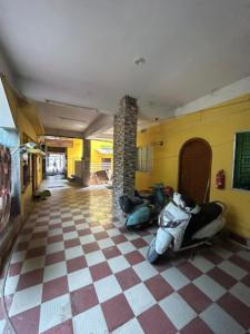 阿加尔塔拉Roop Amrit Guest House , Agartala的一间停放摩托车的房间,房间铺有 ⁇ 格地板