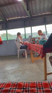 SekenaniLuluka Guest House的坐在桌子上的一群人