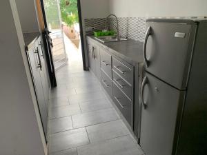 恩加帕鲁Studio Les Hirondelles的带冰箱的厨房和瓷砖地板。