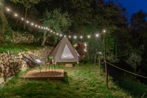 ChiusanicoTipì - Glamping Experience的院子里的帐篷和椅子,配有灯