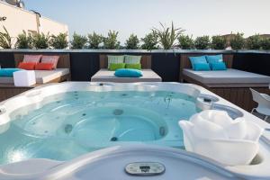 圣特雷莎加卢拉Hotel La Contessa的阳台的按摩浴缸,配有两张床