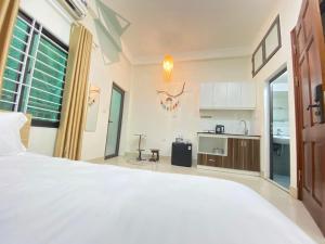 河内Easystay Apartment - 154 Đinh Thôn, Mỹ Đình, Hà Nội的一间带白色大床的卧室和一间厨房