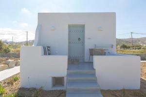 布拉卡Ampelos Plaka的白色的房子,拥有两面白色的墙壁和楼梯