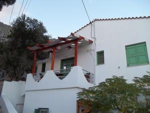 Manganítiszacharoularooms3的白色的建筑,设有绿门和阳台